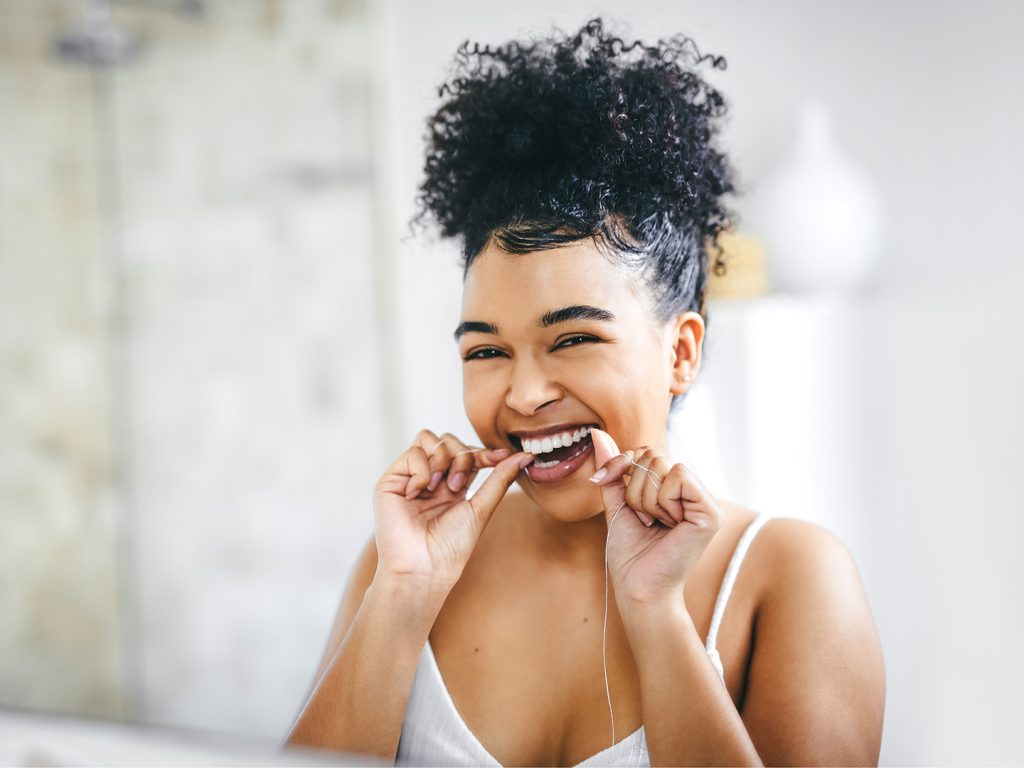 Woman flossing and supporting oral health
